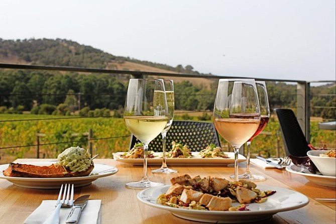 Lunch with glasses of white and rosé on a winery terrace above the vines and the ranges